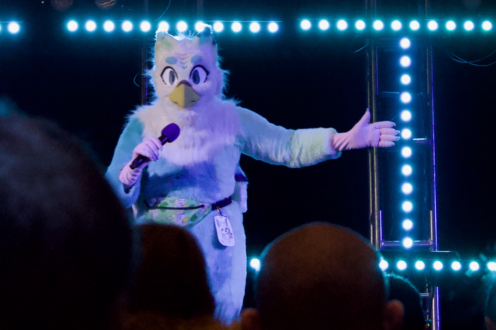 A gryphon fursuiter is on a stage.